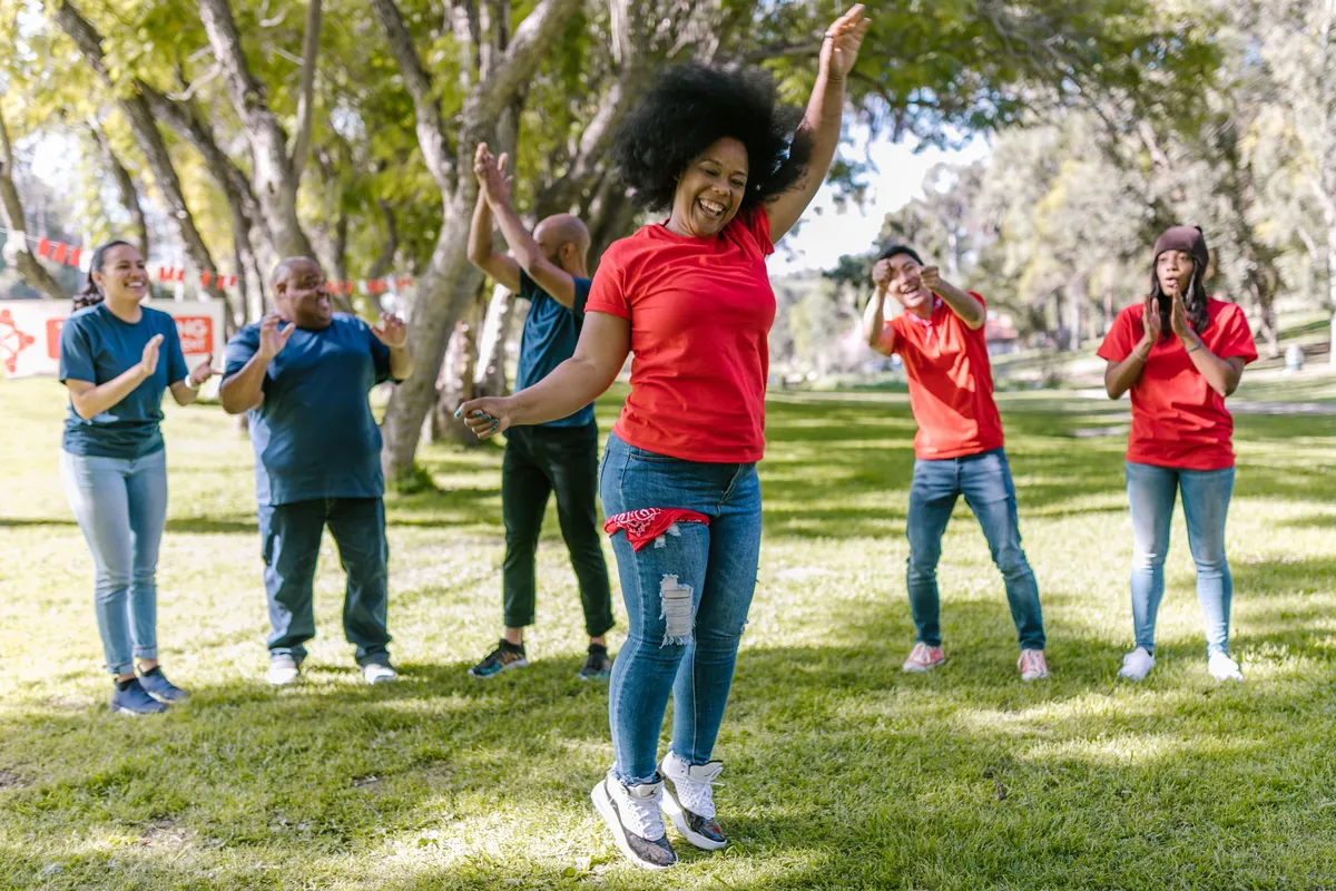 Large diverse group playing a team game outdoors in a park